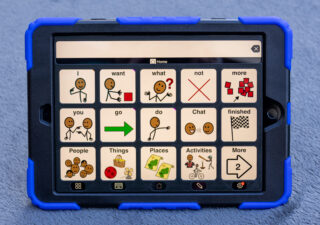 An iPad displaying Proloquo2go 3 by 5 page set with a 3D printed keyguard.