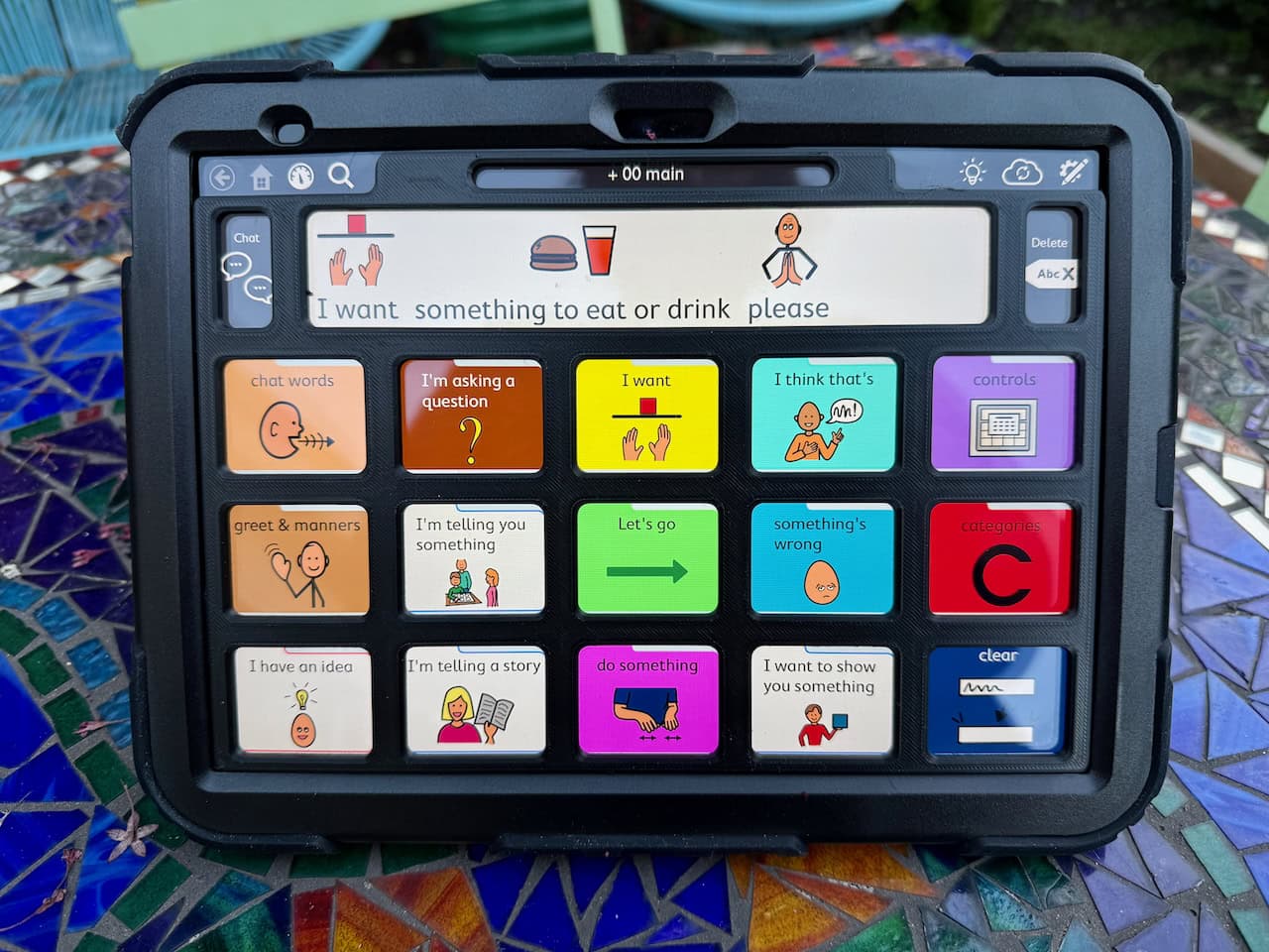 A black keyguard on an iPad with TD Snap PODD page set displayed.