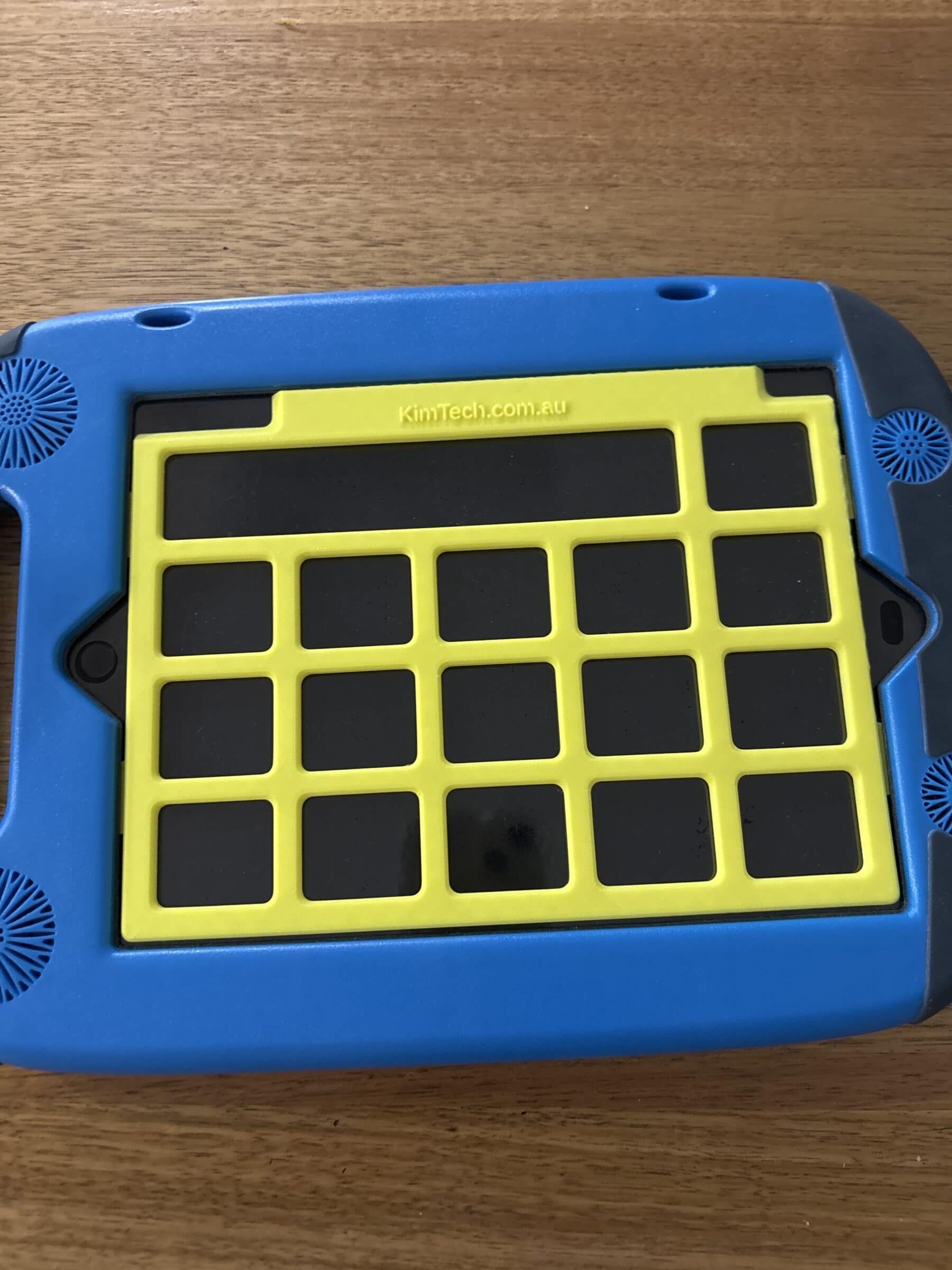 A yellow keyguard on on iPad in a GoNow case. The app displayed on the iPad is PODD 15.