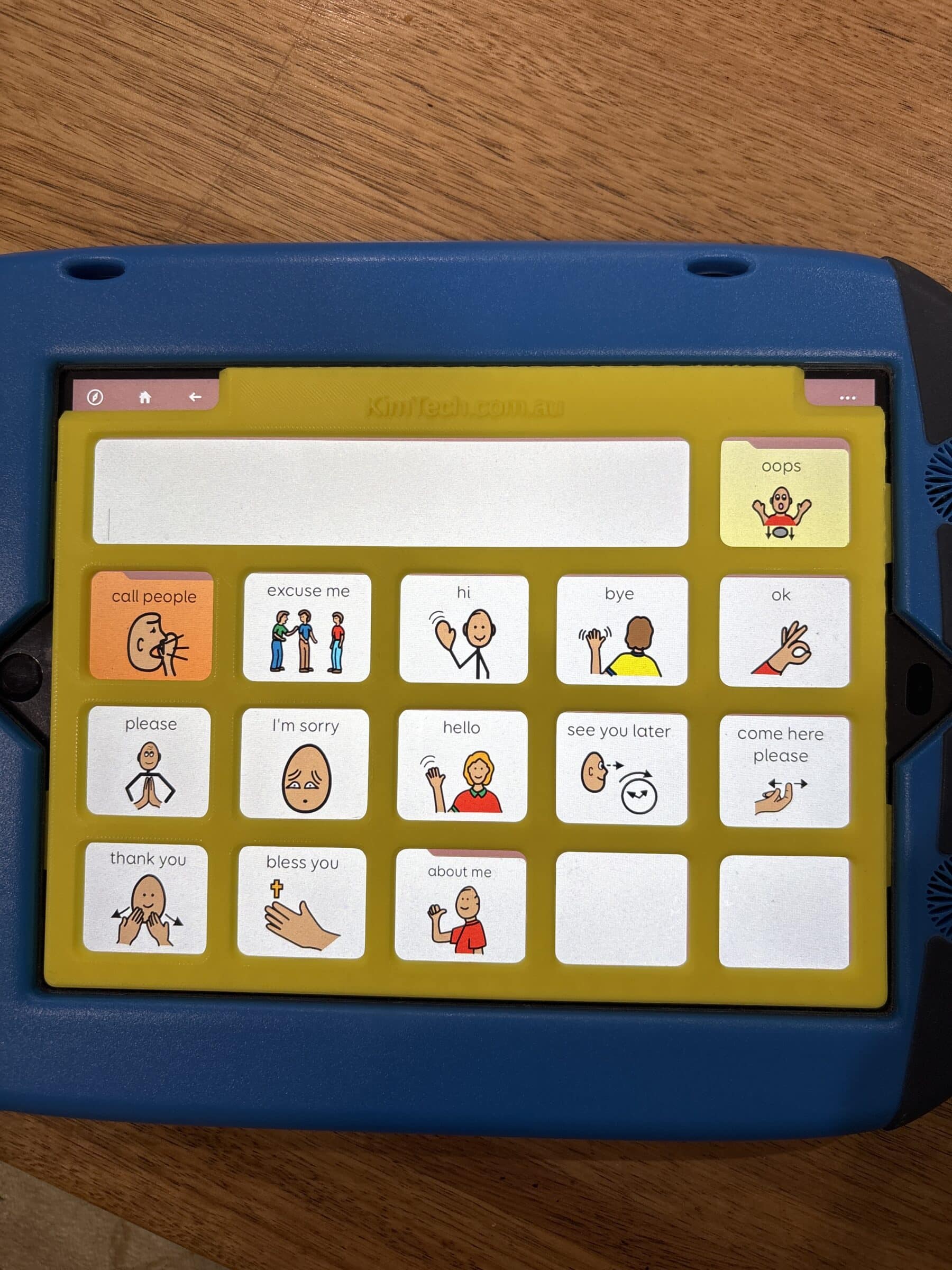 A yellow keyguard on on iPad in a GoNow case. The app displayed on the iPad is PODD 15.