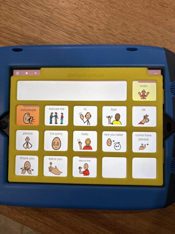 A yellow keyguard on on iPad in a GoNow case. The app displayed on the iPad is PODD 15.